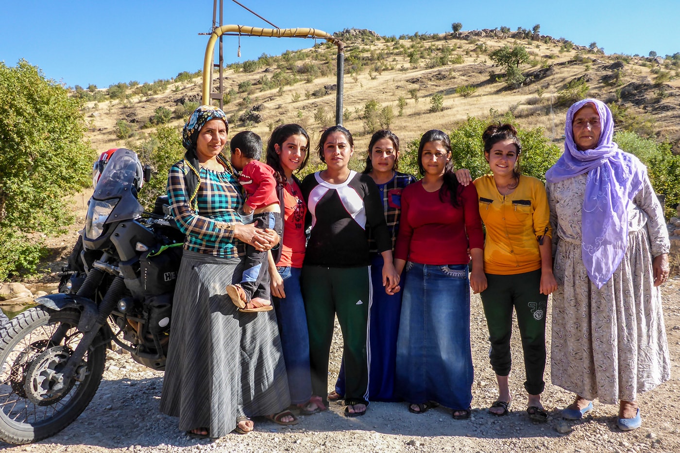 popolo curdo donne al fiume con moto